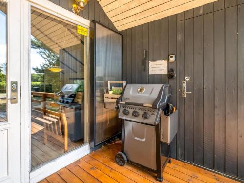 a grill on a porch next to a glass door at Holiday Home Yarla - 500m to the fjord by Interhome in Vemb