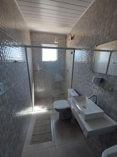 a bathroom with a toilet and a sink and a shower at Suítes XIBAYKA in Ilhabela