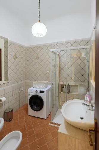 a bathroom with a washing machine and a sink at La casa del Villaggio in Torre Faro