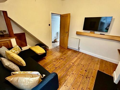 a living room with a couch and a flat screen tv at Nomi Homes - Okehampton Place - Exeter - Sleeps 7 in Exeter