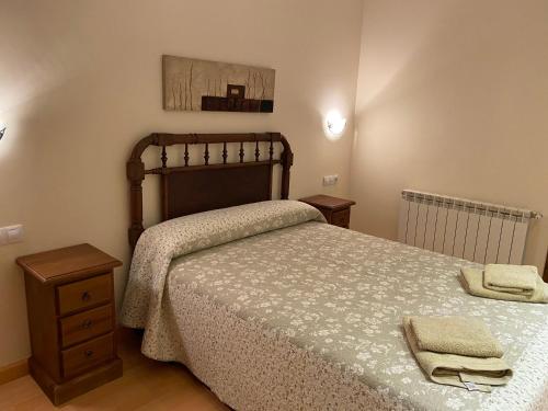 a bedroom with a bed and a dresser with towels on it at Casa Rural Barranco in Bielsa