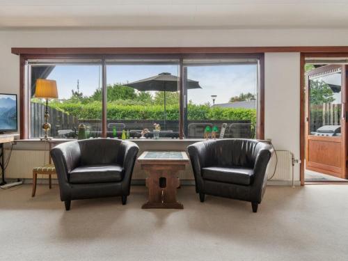 a living room with two chairs and a table at Holiday Home Hildegunda - 280m from the sea by Interhome in Neksø