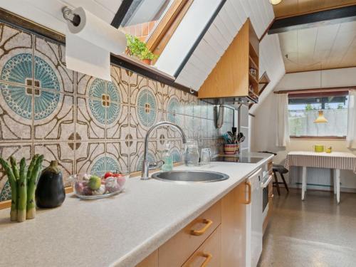 a kitchen with a sink and a tile wall at Holiday Home Hildegunda - 280m from the sea by Interhome in Neksø