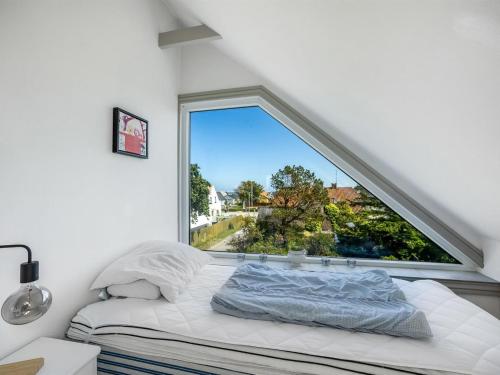 a bed in a room with a large window at Holiday Home Paale - 208m from the sea by Interhome in Læsø