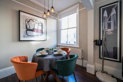 a dining room with a table and chairs and a window at Huge Town Centre 2 Bed Flat with Free Parking in Royal Tunbridge Wells