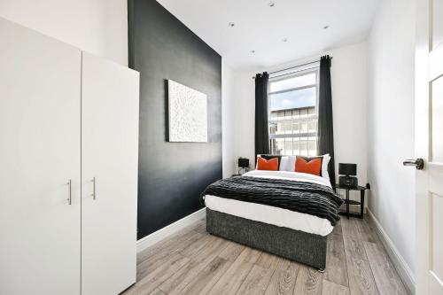 una camera da letto con un letto e una finestra di Superb 1bed Ealing Apartment- Steps to Tube & City Attractions a Ealing