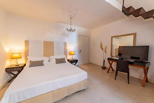 a bedroom with a large white bed and a desk at Hotel Palazzo Cavalieri in Siracusa