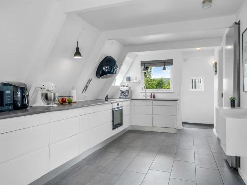 a white kitchen with white cabinets and a window at Holiday Home Ernstine by Interhome in Farsø