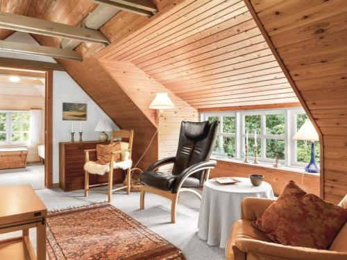 a living room with wooden ceilings and a black chair at Holiday Home Hilaria - 2-1km from the sea by Interhome in Aså