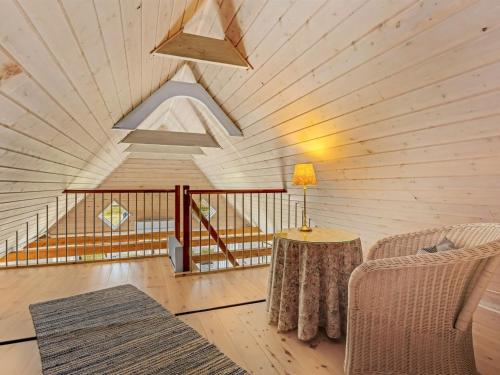 a room with a wooden ceiling with a table and a couch at Apartment Ronja - 1-3km from the sea by Interhome in Læsø