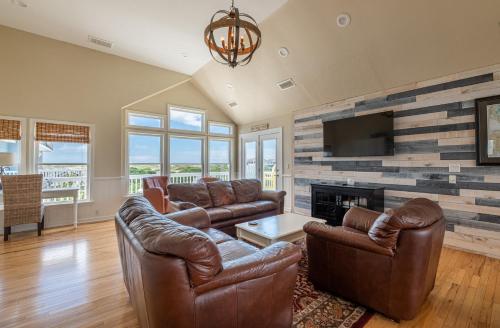 a living room with leather furniture and a flat screen tv at Patriots Place- C1776 in Poplar Branch
