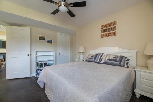 a bedroom with a white bed and a ceiling fan at Patriots Place- C1776 in Poplar Branch