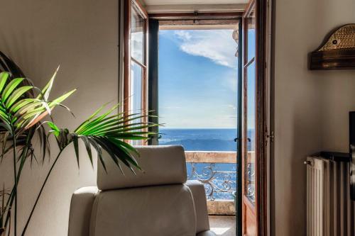 a room with a chair and a view of the ocean at Almost Paradise by Quokka 360 - flat with a view of Lake Como in Brunate