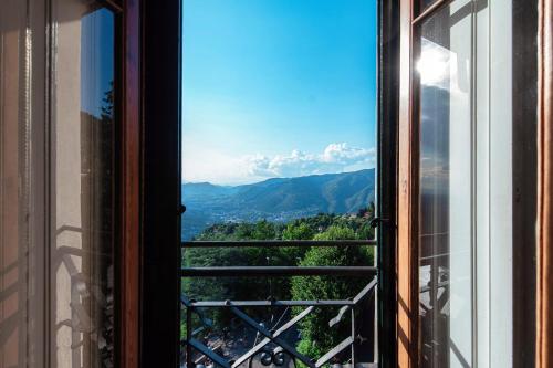 an open window with a view of the mountains at Almost Paradise by Quokka 360 - flat with a view of Lake Como in Brunate
