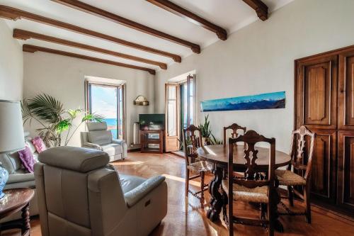 a living room with a table and chairs and a couch at Almost Paradise by Quokka 360 - flat with a view of Lake Como in Brunate