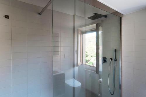 a shower with a glass door in a bathroom at Almost Paradise by Quokka 360 - flat with a view of Lake Como in Brunate