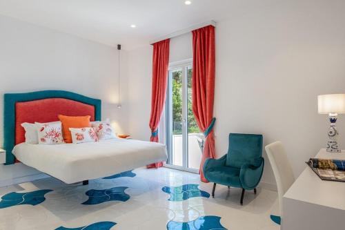 a bedroom with a bed and a blue chair at Villa Coralia Luxury Suite in Amalfi Coast, Sorrento, Italia in Sorrento