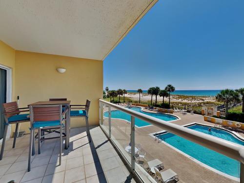 a balcony with a view of the pool and the ocean at Emerald Isle #106 in Pensacola Beach