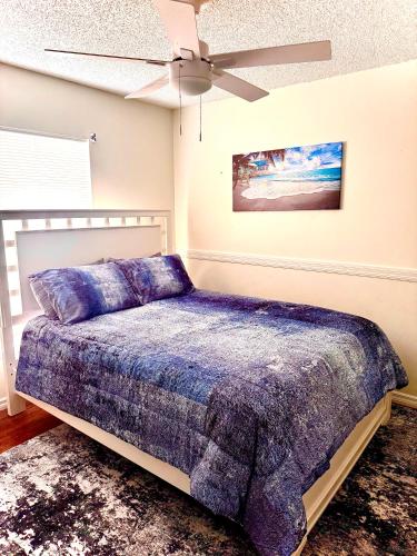 Un dormitorio con una cama y un ventilador de techo. en Tropical Paradise, en Orlando