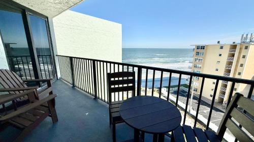 a balcony with a table and chairs and the ocean at Top-floor ocean view condo with a private balcony and beachfront pool in Edgewater