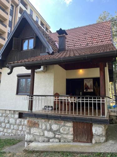 a house with a balcony with a roof at Vila Lika in Zlatibor