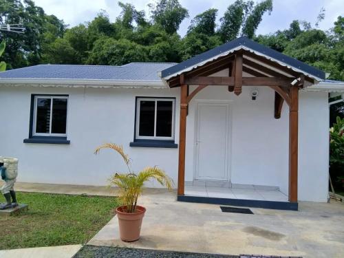 a white house with a porch and a white door at Maison cosy à Lamentin, 20m², climatisation in Lamentin