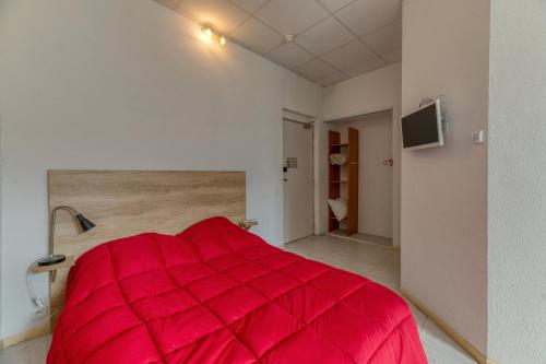 a large red bed in a white room at Logis Belledonne in Arvillard