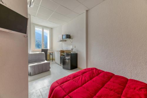 a living room with a red couch and a television at Logis Belledonne in Arvillard