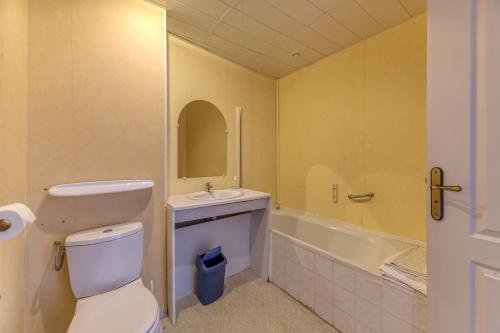 a bathroom with a toilet and a sink and a tub at Logis Belledonne in Arvillard