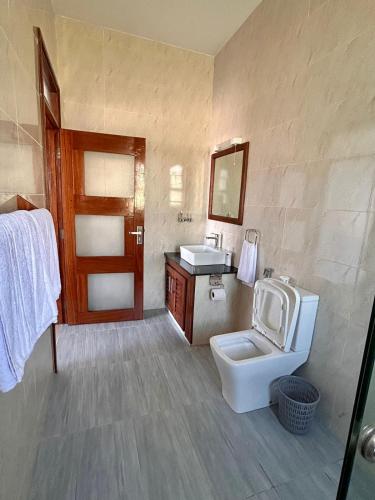 a bathroom with a toilet and a sink at Knysna Home, Vipingo in Kilifi