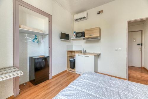 a small room with a bed and a kitchen at Logis Belledonne in Arvillard