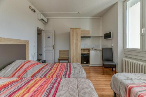 a bedroom with two beds and a kitchen at Logis Belledonne in Arvillard