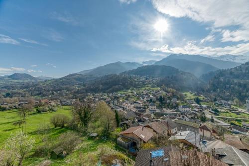 a village in a valley with mountains in the background at Logis Belledonne in Arvillard