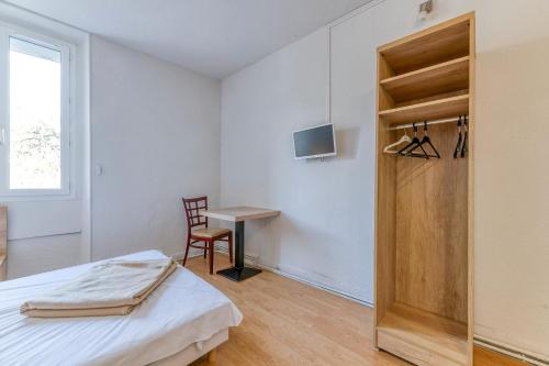 a bedroom with a bed and a desk and a chair at Logis Belledonne in Arvillard