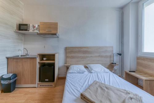 a small room with a bed and a kitchen at Logis Belledonne in Arvillard
