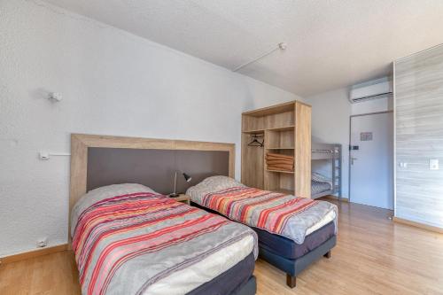 a bedroom with two beds and a closet at Logis Belledonne in Arvillard