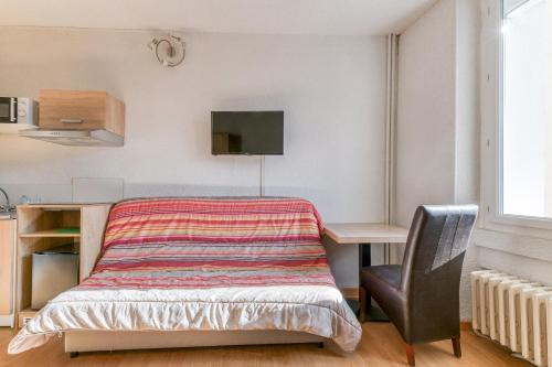 a bedroom with a desk with a bed and a chair at Logis Belledonne in Arvillard