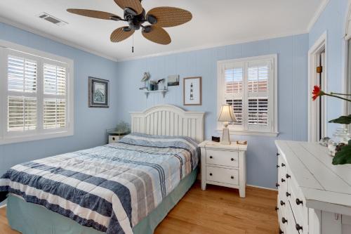 a blue bedroom with a bed and a ceiling fan at 4018 - Shorely Bliss in Kitty Hawk