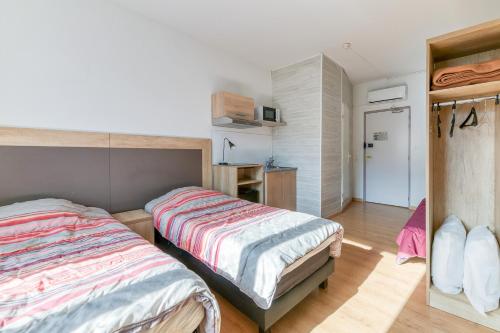 a bedroom with two beds and a closet at Logis Belledonne in Arvillard