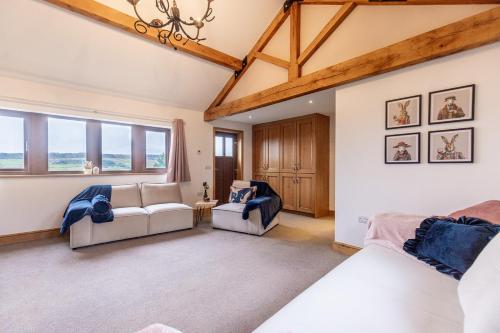 a bedroom with a bed and a couch and windows at GARDEN FIELD COTTAGE - Spacious Holmbridge Home with Rolling Hill Views in Holmbridge