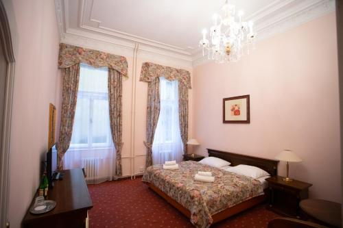 a bedroom with a bed and a chandelier at Hotel Ester in Karlovy Vary