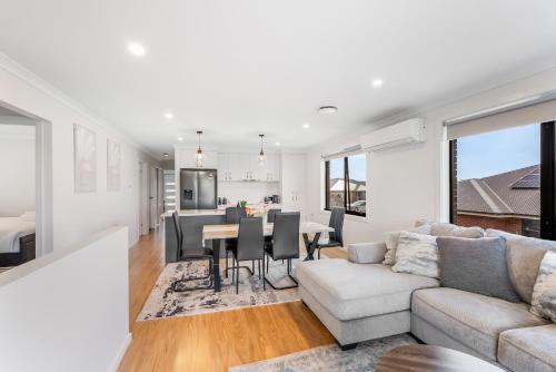a living room with a couch and a table at New Stylish Family Escape with Deck - 7 mins to MONA in Austins Ferry