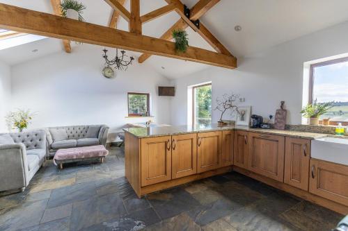 a kitchen with wooden cabinets and a living room at GARDEN FIELD COTTAGE - Spacious Holmbridge Home with Rolling Hill Views in Holmbridge