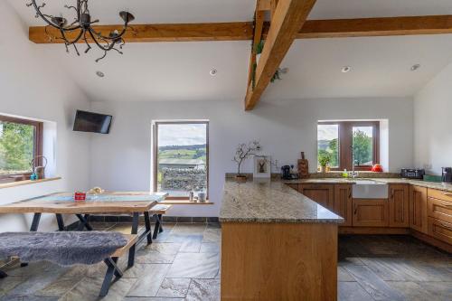 a large kitchen with a table and a dining room at GARDEN FIELD COTTAGE - Spacious Holmbridge Home with Rolling Hill Views in Holmbridge