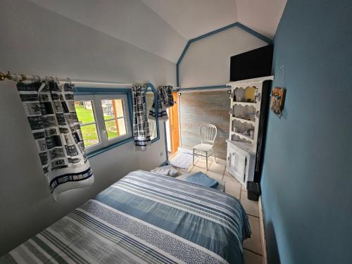 Un dormitorio pequeño con una cama y una ventana. en Le clos des oiseaux, en Maisnières