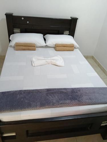 a bed with a pair of white shoes on it at Cabaña velez in Capurganá