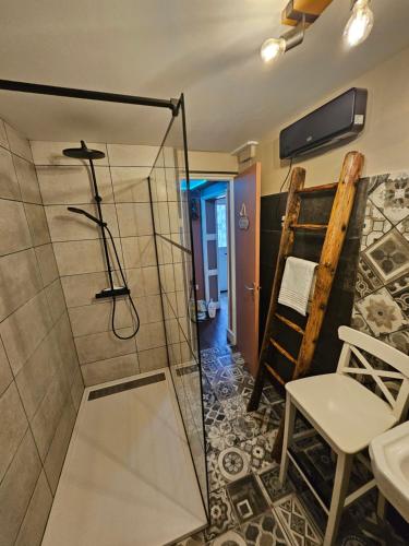 Un baño con ducha con puerta de cristal en Le clos des oiseaux, en Maisnières
