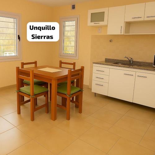 une cuisine avec une table en bois et deux chaises dans l'établissement Unquillo Cordoba departamento con parilla, à Unquillo
