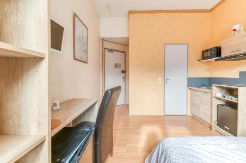 a small room with a bed and a kitchen at Logis Belledonne in Arvillard