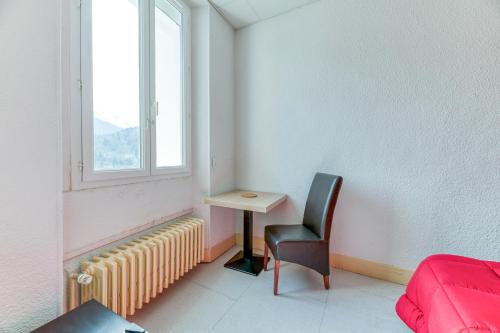 a room with a desk and a chair and a window at Logis Belledonne in Arvillard